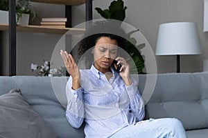 Unhappy African American woman have unpleasant cell call photo