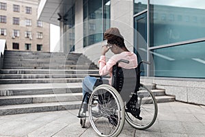 Unhappy young black woman suffering from lack of wheelchair friendly facilities, cannot get home without ramp, copy