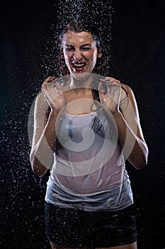 Unhappy young brunette under running water