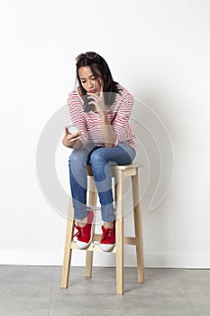Unhappy young female student thinking in reading her messages on her mobile phone