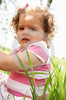 Unhappy Young Girl Sitting In Summer Field