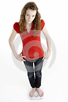 Unhappy Young Girl Standing On Scales