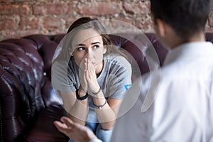 Unhappy young girl visiting at the psychologist