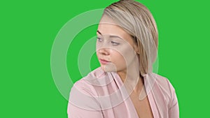 Unhappy young girl waiting for phone ring despairingly on a Green Screen, Chroma Key.