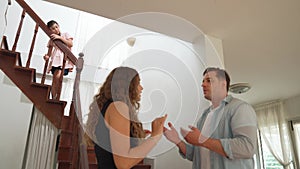 Unhappy young girl watch her parent arguing from the stair. Fastidious