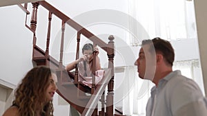 Unhappy young girl watch her parent arguing from the stair. Fastidious