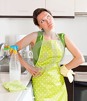 Unhappy young housewife cleaning furniture