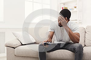 Unhappy young man at home playing video games and loses