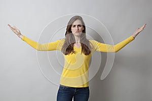 Unhappy young woman with arms wide open