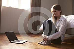 Unhappy Young Woman Being Bullied Online With Laptop