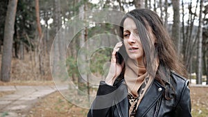 Unhappy young woman is talking on phone, angry outdoors