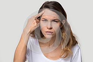 Unhappy young woman touching forehead, worried about acne or wrinkle