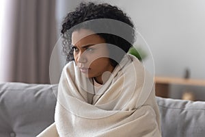 Unhealthy african American woman covered in blanket feel unwell