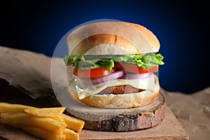 Unhealthy Fast Food - Burger on a wooden block with French Fries