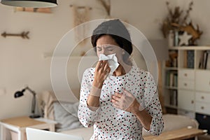 Unhealthy female sneeze wipe nose with tissue suffer of rhinitis