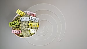 Unhealthy food: chemical additives in the form of granules with colored labels. Top view.