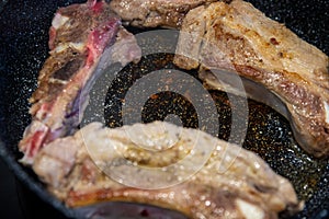 unhealthy frying meat on a damaged coating in a pan