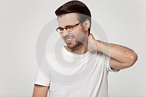 Unhealthy man in glasses massage neck suffering from pain