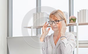 Unhealthy mature woman touch forehead suffers from migraine strong headache, woman massaging temples close up, suffering from