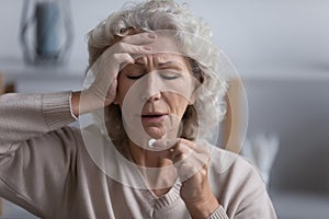 Unhealthy senior female having medicine at home