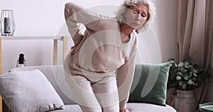 Unhealthy senior mature retired grandmother suffering from osteoporosis arthritis.