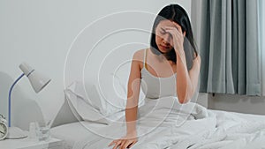 Unhealthy sick Indian female suffers from insomnia. Asian young woman taking painkiller medicine to relieve headache pain.