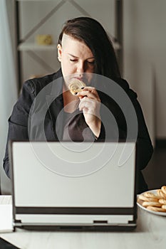 Unhealthy snack at work time, woman overeating