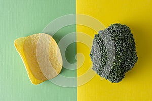 Unhealthy versus healthy food. Choise concept. Potatoe chips or broccoli. Top view, colorful background