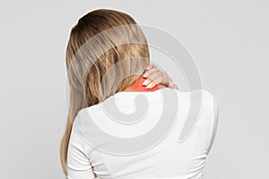 Unhealthy woman with pain in her neck and back, coloured in red, back view. Cervical arthritis, osteochondrosis photo