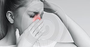 Unhealthy woman in pain touching her head and nose