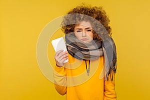 Unhealthy woman wrapped in scarf holds napkin, suffering runny nose and sore throat, symptoms of flu