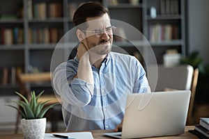 Unhealthy young man massage neck suffering from back spasm