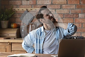 Unhealthy young man struggle with backache at workplace