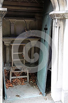 unhinged door and broken chair on cemetery