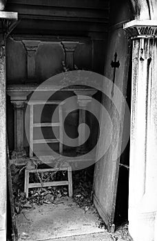 unhinged door and broken chair on loculus of the cemetery