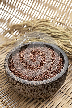 unhulled asian red rice grains in rustic setting display in Cambodia