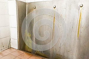 Unhygienic dirty urinal with limescale stain built up