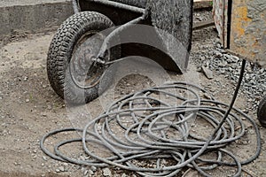 Unicycle wheelbarrow and electric cable at the construction site