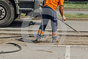 Unidentifiable road maintenance worker repairing driveway