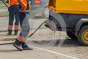 Unidentifiable road maintenance workers repairing driveway