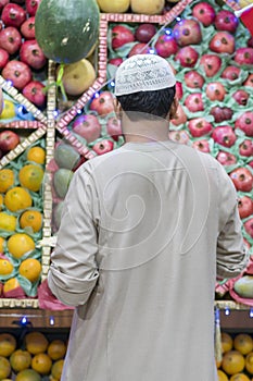 Unidentified Arabian man on the street sell local vegetable and fruits. man selling vegetables on a market