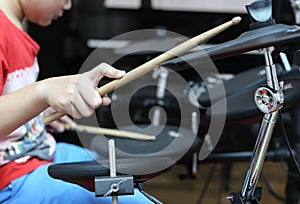 Unidentified Asian boy play electronic drum electronic drum