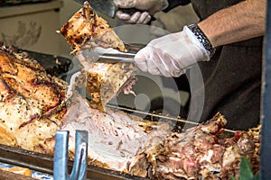 Unidentified chef cuting roasted pig