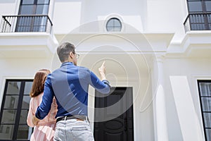 Unidentified couple pointing at the new house