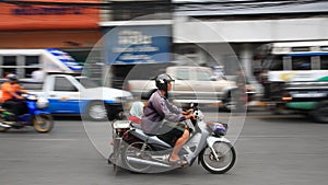 Unidentified family riding motorcycle in town