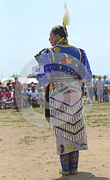 Unidentified female Native American dancer wears traditional Pow Wow dress