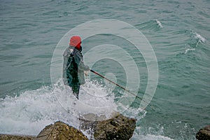 Unidentified fisherman standing in a rock with a fishing rod on chilean patagonia