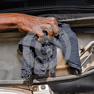 Unidentified Ghanaian man wipes out car detail with a rag.