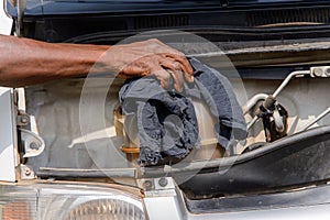 Unidentified Ghanaian man wipes out car detail with a rag.