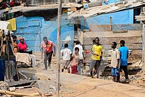 Unidentified Ghanaian people walk on the shore of Elmina port.